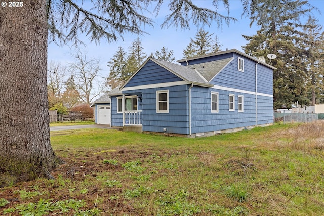 view of side of property featuring a yard and a garage