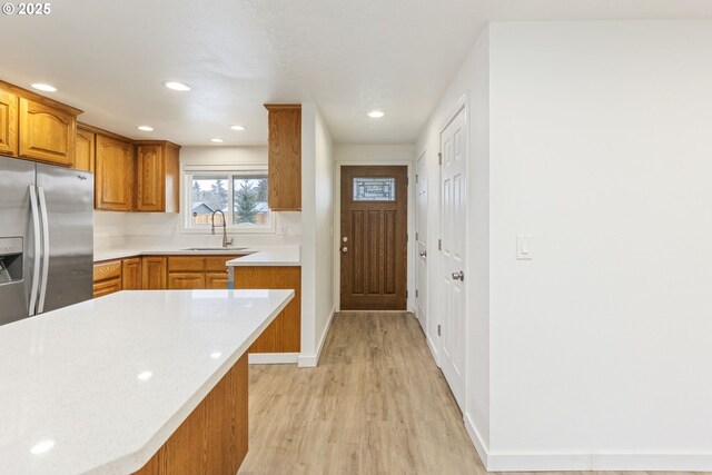 6253 SW 204th Pl, Beaverton, OR 97078 - kitchen featuring stainless steel fridge, brown cabinets, light wood-style floors, light countertops, and recessed lighting