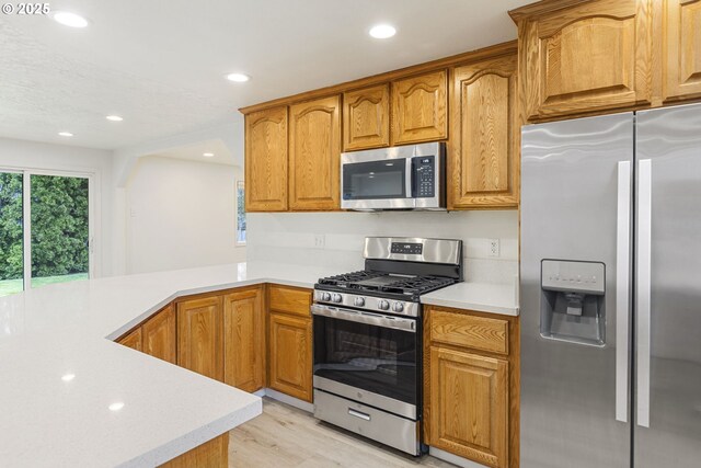 6253 SW 204th Pl, Beaverton, OR 97078 - kitchen with stainless steel appliances, light countertops, recessed lighting, light wood-style floors, and a peninsula