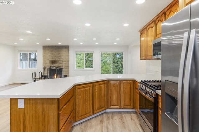 6253 SW 204th Pl, Beaverton, OR 97078 - kitchen with stainless steel appliances, light wood finished floors, light countertops, a peninsula, and recessed lighting