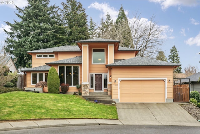 prairie-style home featuring concrete driveway, a shingled roof, fence, a front lawn, and a garage