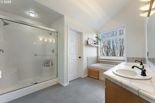 bathroom with vaulted ceiling, tile patterned floors, a sink, and a shower stall