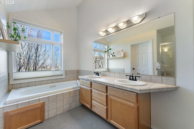 bathroom with double vanity, tile patterned flooring, vaulted ceiling, and a sink