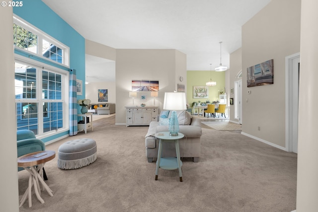 carpeted living room featuring an inviting chandelier and a high ceiling