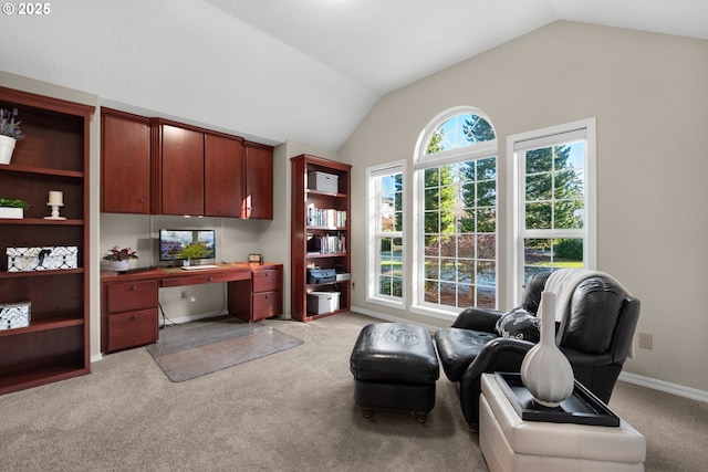 carpeted home office with vaulted ceiling