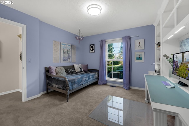 bedroom with light colored carpet and a textured ceiling