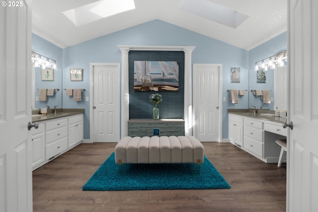 bathroom featuring vanity, hardwood / wood-style floors, and vaulted ceiling with skylight