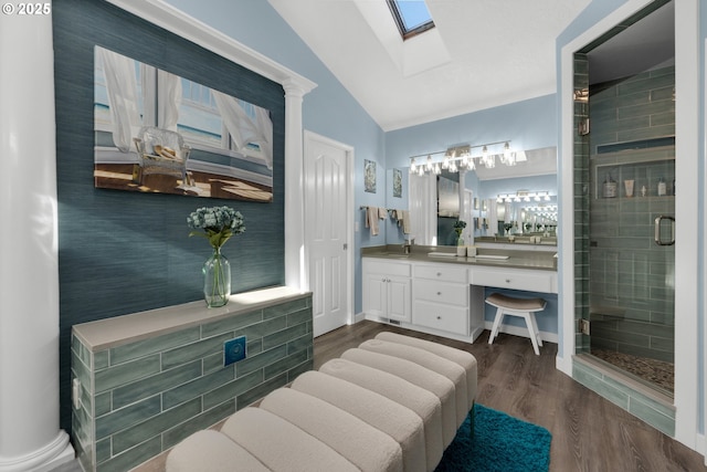 bathroom featuring vanity, hardwood / wood-style floors, vaulted ceiling with skylight, and walk in shower