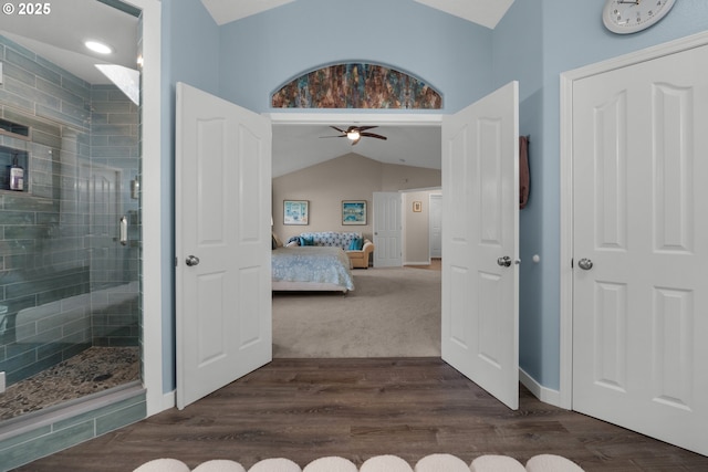 bathroom featuring walk in shower, ceiling fan, lofted ceiling, and hardwood / wood-style floors