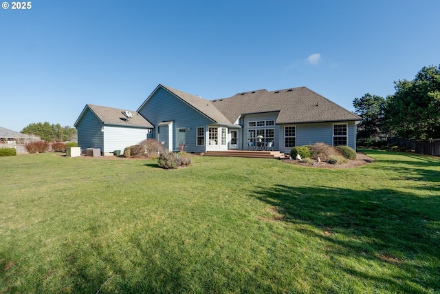 rear view of house featuring a wooden deck and a yard