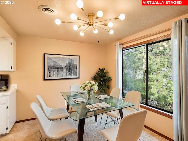 dining area with a notable chandelier, light colored carpet, a textured ceiling, and a wealth of natural light