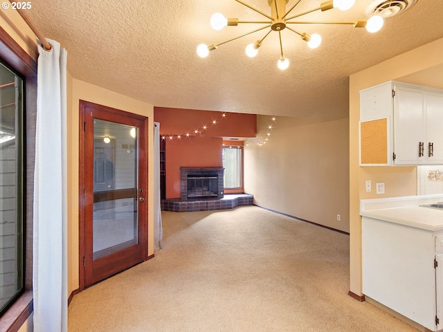 unfurnished living room featuring light colored carpet, a textured ceiling, and a fireplace