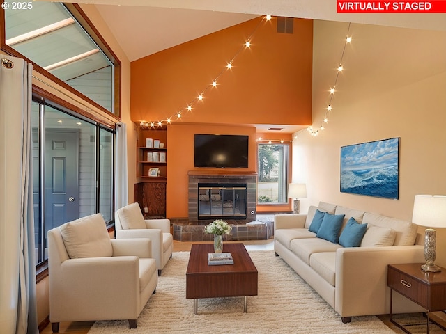 living room featuring built in features, high vaulted ceiling, and a tile fireplace