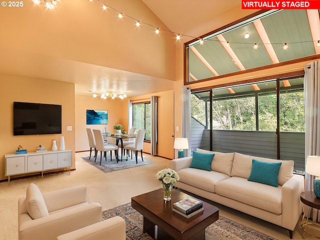 carpeted living room featuring high vaulted ceiling