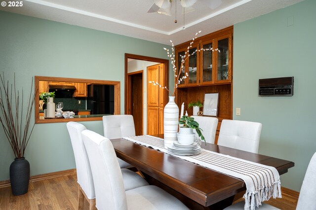 dining room with baseboards, a ceiling fan, and wood finished floors