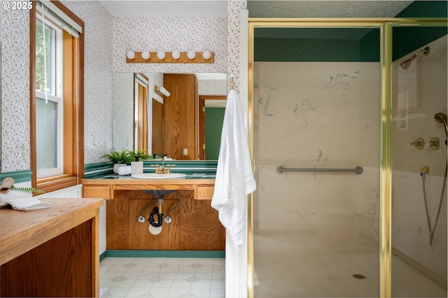 bathroom with vanity, a stall shower, and wallpapered walls