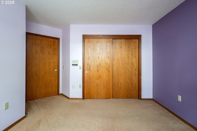 unfurnished bedroom with carpet flooring, baseboards, and a closet
