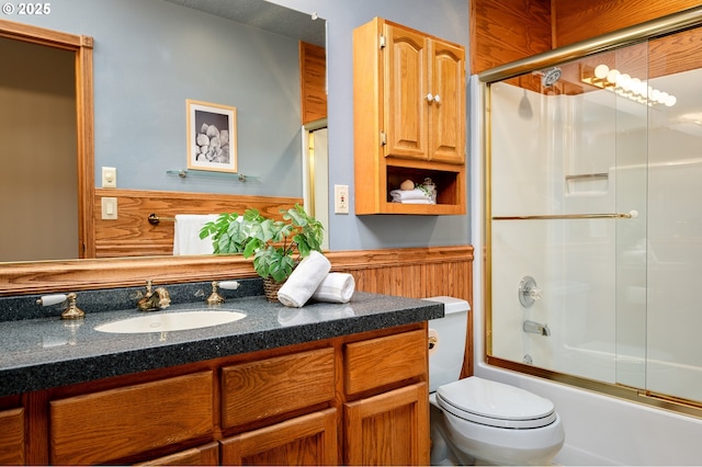 bathroom with vanity, enclosed tub / shower combo, and toilet