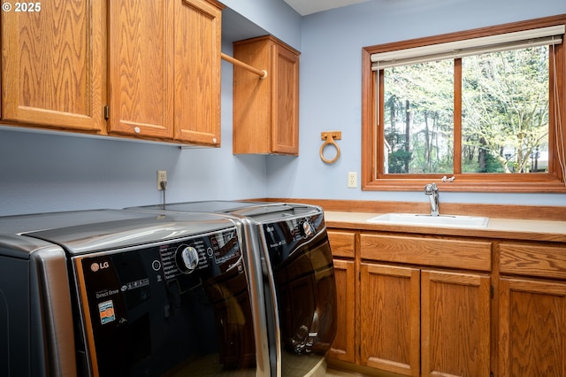 washroom featuring a sink, cabinet space, and washer and dryer