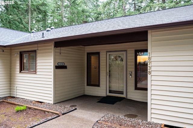 entrance to property with roof with shingles