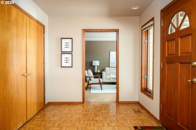 entrance foyer with baseboards, plenty of natural light, and a textured ceiling