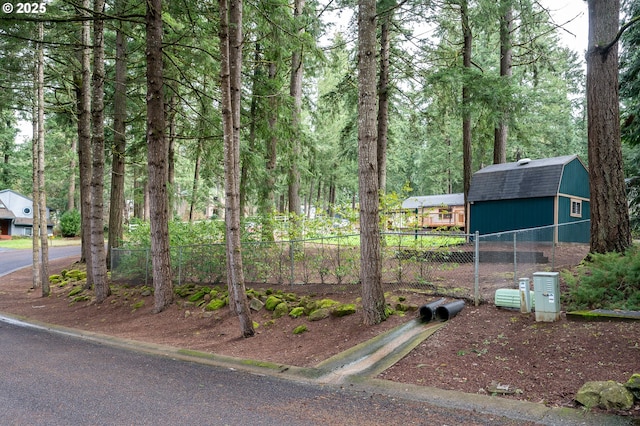view of yard featuring an outdoor structure and fence