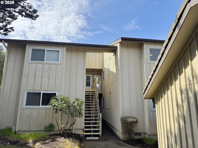 view of side of property with stairway and board and batten siding