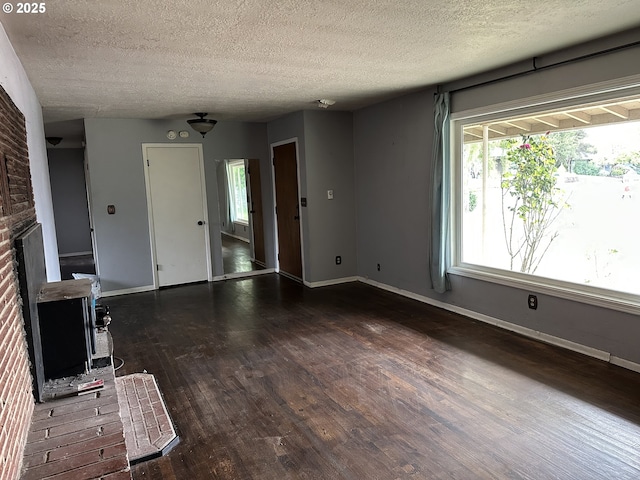 515 May St, Molalla, OR 97038 - unfurnished living room with a textured ceiling, baseboards, wood finished floors, and a fireplace