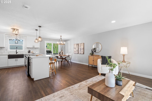 living area featuring dark wood-style floors, baseboards, and recessed lighting