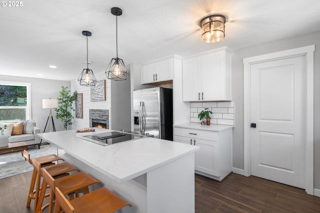 kitchen with dark wood finished floors, backsplash, white cabinetry, stainless steel fridge with ice dispenser, and black electric cooktop