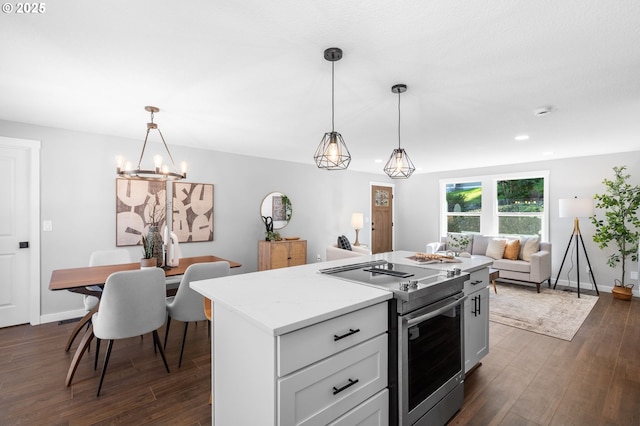 kitchen with stainless steel electric range oven, a kitchen island, open floor plan, dark wood-style flooring, and decorative light fixtures