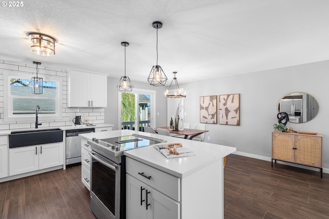 kitchen with stainless steel appliances, dark wood-type flooring, a kitchen island, and a sink