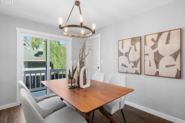 dining space with a chandelier, baseboards, and wood finished floors