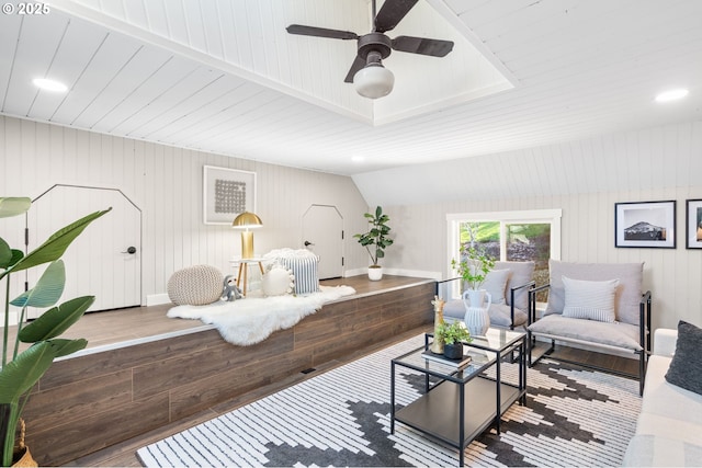 living area featuring lofted ceiling, ceiling fan, and wood finished floors