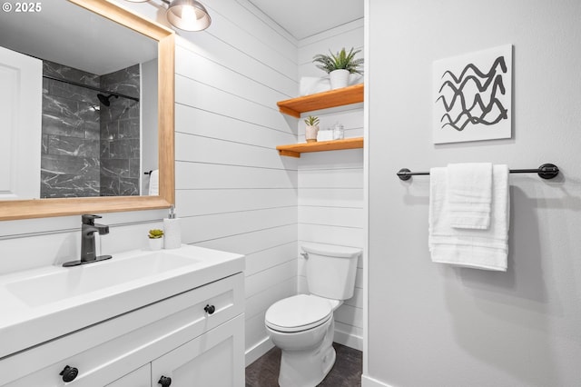 bathroom featuring baseboards, a shower, toilet, vanity, and wood walls