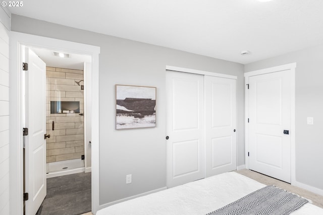 bedroom with ensuite bathroom, a closet, visible vents, and baseboards