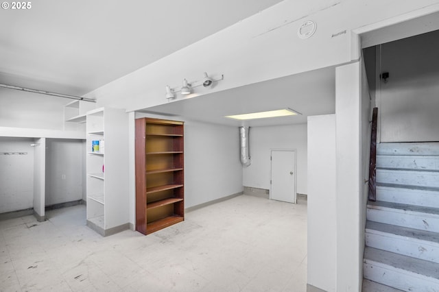 finished basement with stairway and tile patterned floors