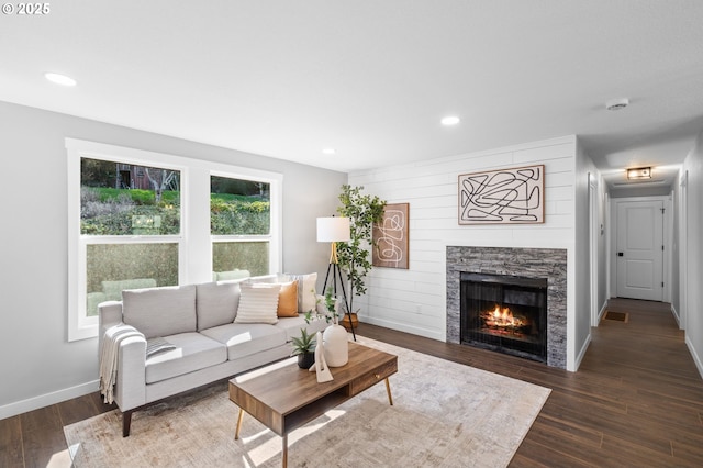 living area featuring a fireplace, recessed lighting, wood finished floors, and baseboards