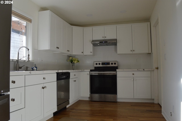 kitchen with under cabinet range hood, stainless steel appliances, dark wood-style flooring, a sink, and white cabinets