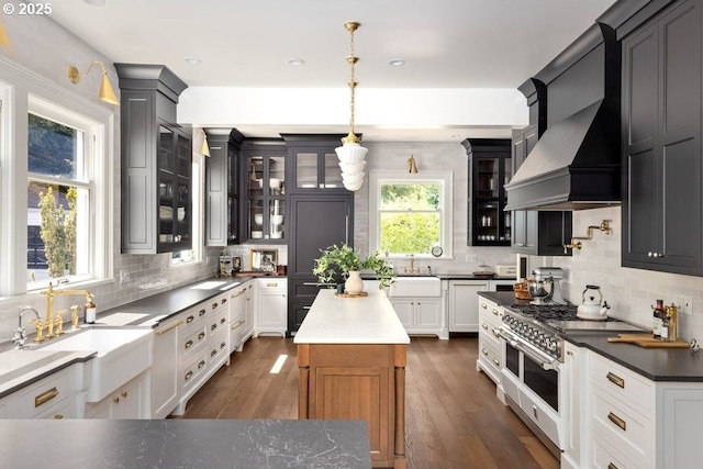 11175 S Riverwood Rd, Portland, OR 97219 - kitchen featuring range with two ovens, custom exhaust hood, tasteful backsplash, glass insert cabinets, and dark wood-style floors