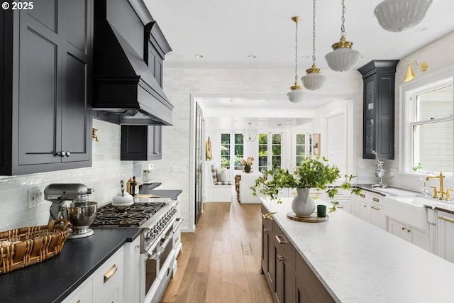 11175 S Riverwood Rd, Portland, OR 97219 - kitchen featuring premium range hood, backsplash, light wood-style flooring, double oven range, and decorative light fixtures