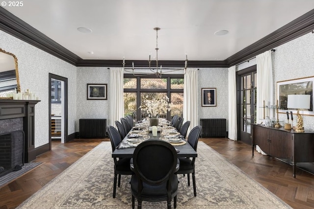 11175 S Riverwood Rd, Portland, OR 97219 - dining space with ornamental molding, radiator, wallpapered walls, a brick fireplace, and a chandelier