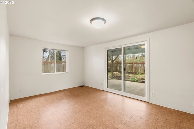 empty room featuring tile patterned floors, baseboards, and plenty of natural light