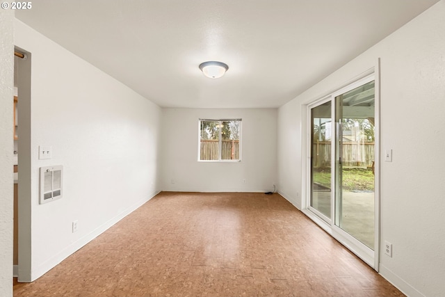 unfurnished room featuring visible vents, a healthy amount of sunlight, and baseboards