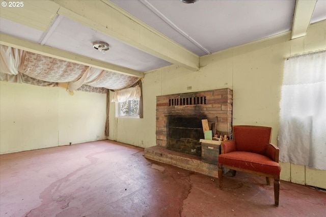 living area with beam ceiling, a fireplace with raised hearth, and unfinished concrete flooring