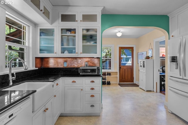 414 NW Riverside Blvd, Bend, OR 97703 - kitchen with fridge with ice dispenser, arched walkways, dishwasher, white cabinets, and plenty of natural light