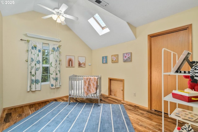 sitting room with vaulted ceiling with skylight, ceiling fan, wood finished floors, and visible vents