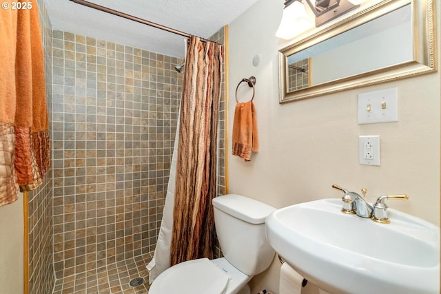 full bathroom with a sink, toilet, and tiled shower