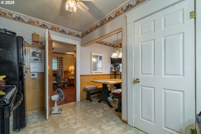 860 Adams St, Eugene, OR 97402 - kitchen featuring black range, light floors, a wainscoted wall, wooden walls, and a ceiling fan