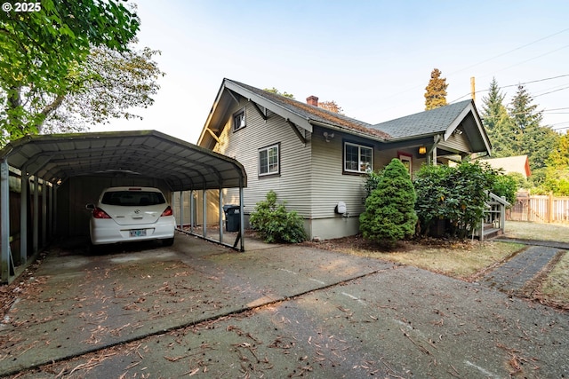 860 Adams St, Eugene, OR 97402 - view of home's exterior with a detached carport, concrete driveway, and a chimney